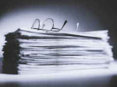 image of reading glasses on top of stacked papers