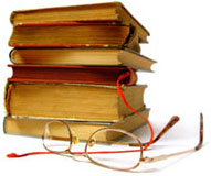 image of reading glasses in front of stacked books